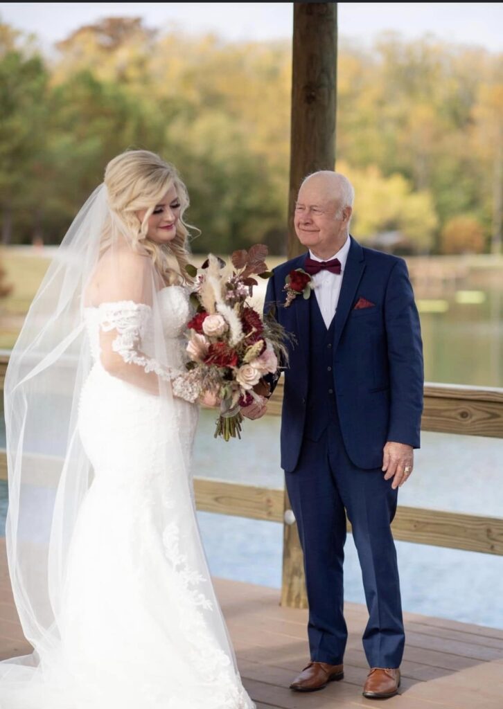 Bride with father holding flower bouquet